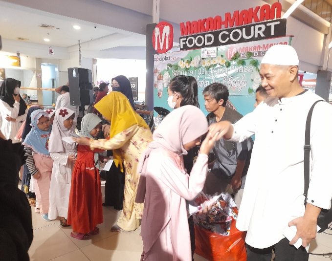 Hanafi beserta tim penyelenggara sedang membagikan bingkisan dan santunan. (31/03/2023).