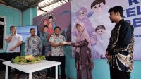 Camat Cilodong, Zaenal Arifin memberikan potongan tumpeng kepada Branch Manager Rumah Zakat Depok, Novita Maharani.