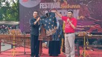 Aspemkesra Setda Depok, Gandara Budiana (kiri) saat menerima Batik Sukma dari Camat Sukmajaya, Wiyana sebagai simbol diluncurkannya kembali Batik Sukma pada Festival Sukma dan Depok Keren 2024 di Taman Merdeka, Kecamatan Sukmajaya.