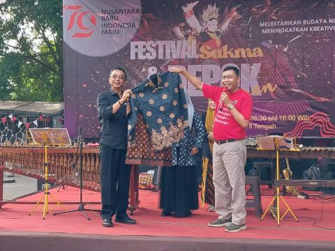 Aspemkesra Setda Depok, Gandara Budiana (kiri) saat menerima Batik Sukma dari Camat Sukmajaya, Wiyana sebagai simbol diluncurkannya kembali Batik Sukma pada Festival Sukma dan Depok Keren 2024 di Taman Merdeka, Kecamatan Sukmajaya.