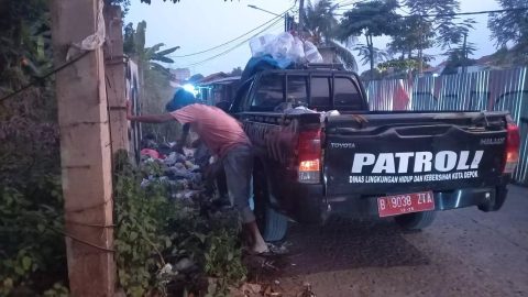 Petugas DLHK Depok membersihkan sampah yang ada di tepi Jalan Pendowo Limo. (dok. Narasumber)