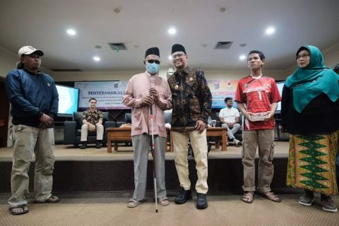 Wakil Wali Kota Depok Imam Budi Hartono (tengah) saat menyerahkan alat bantu tongkat kepada penyandang disabilitas.