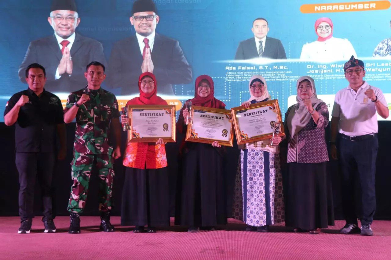Pj Sekda Kota Depok Nina Suzana menyerahkan penghargaan Anugerah Inovasi Perangkat Daerah dalam rangkaian acara Depok Media Arts Summit 2024.