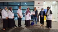 Kepala Bidang Perlindungan Jaminan Sosial dan Korban Bencana Dinsos Kota Depok, Ambar Hardiani Widjajanti menyerahkan bansos sankem secara simbolis. (dok. Dinsos Depok).