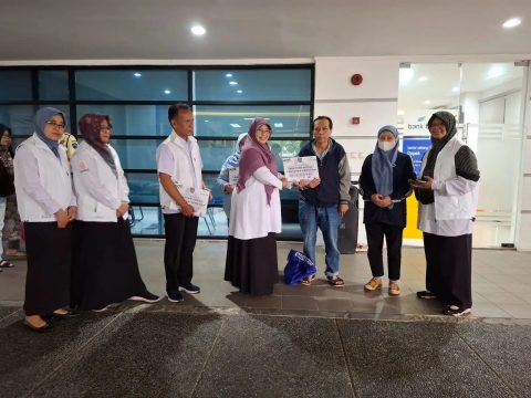 Kepala Bidang Perlindungan Jaminan Sosial dan Korban Bencana Dinsos Kota Depok, Ambar Hardiani Widjajanti menyerahkan bansos sankem secara simbolis. (dok. Dinsos Depok).