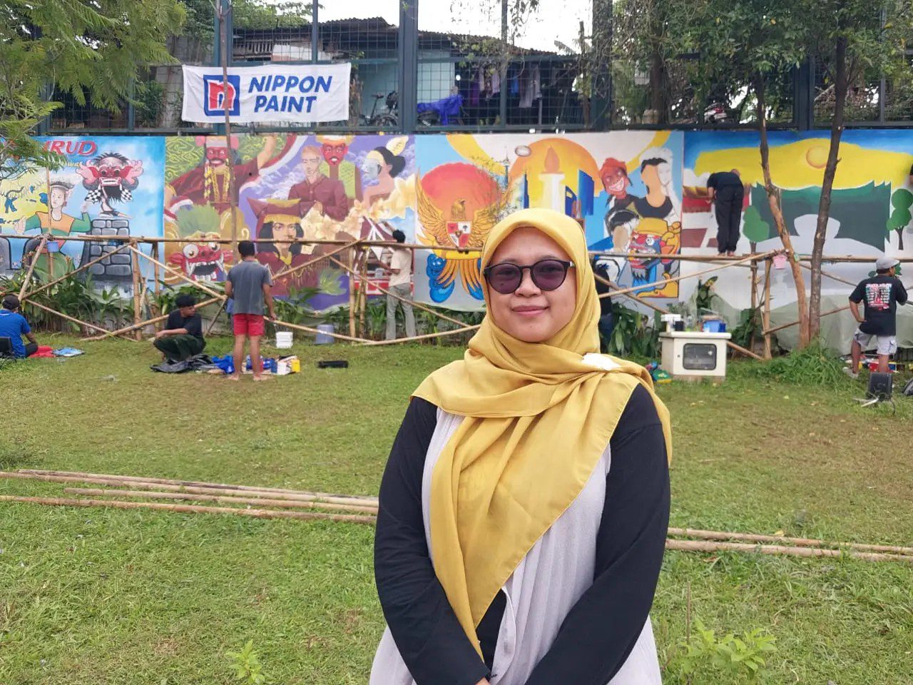Kepala UPTD Taman Hutan Raya Kota Depok, Lintang Yuniar Pratiwi meninjau pelaksanan Lomba Mural di Alun-alun Depok.