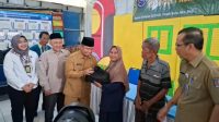 Wali Kota Depok Supian Suri secara simbolis menyerahkan sembako kepada warga dalam kegiatan Pasar Murah Ramadan