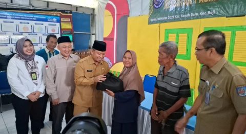 Wali Kota Depok Supian Suri secara simbolis menyerahkan sembako kepada warga dalam kegiatan Pasar Murah Ramadan