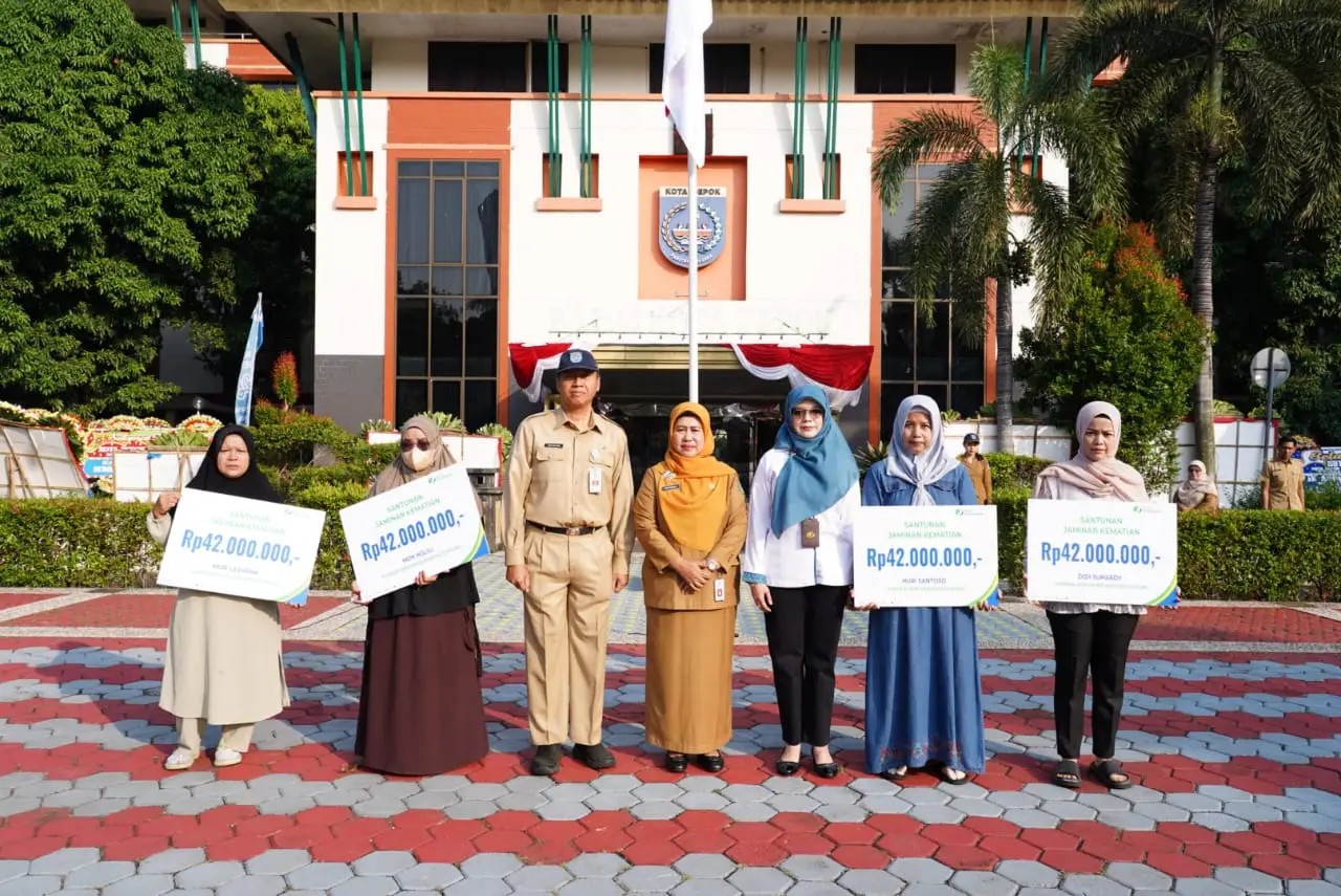 Pj Sekda Kota Depok, Nina Suzana menyerahkan secara simbolis klaim santunan kematian kepada ahli waris pekerja rentan. (dok.Humas Pemkot Depok).