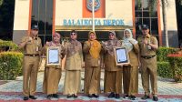 Penjabat Sekda Kota Depok, Nina Suzana (tengah) Bersama Staf Ahli Wali Kota dan Kepala Diskominfo dan empat perangkat daerah penerima Sertifikat ISO/IEC 27001:2022.