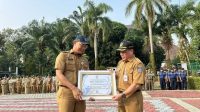 Sekda Kota Depok, Mangguluang Mansur, menyerahkan penghargaan kepada Kepala BKPSDM Kota Depok.